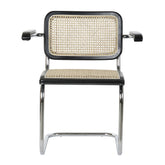 Modern fémvázas, fekete színű, rattan betétes karosszék.